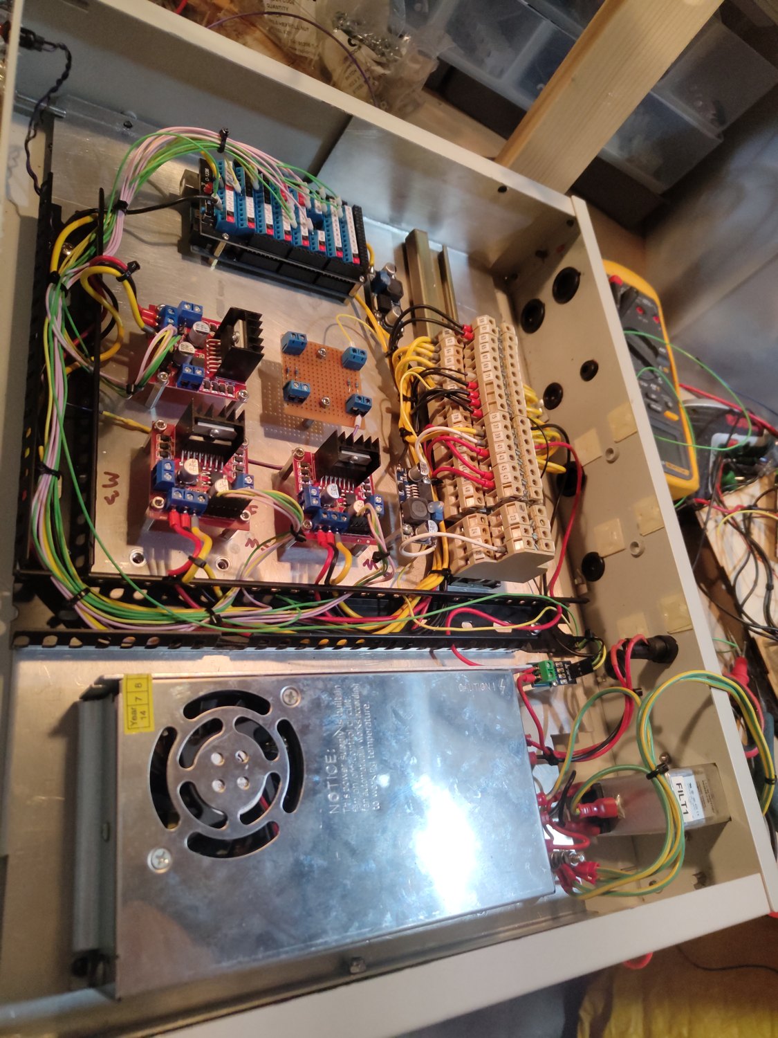 A custom robot controller mid-build — a 19-inch unit packed with drivers, power supplies and wiring being assembled and loomed
